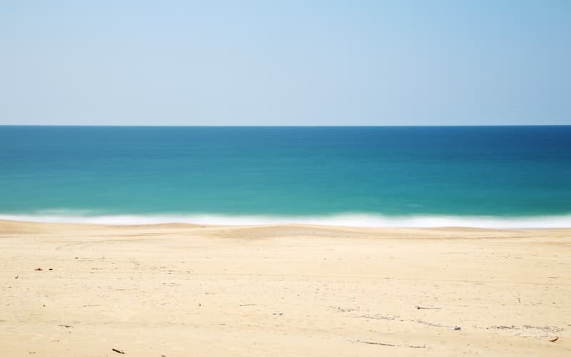 Beachcomber searching for sea glass on a sandy shore
