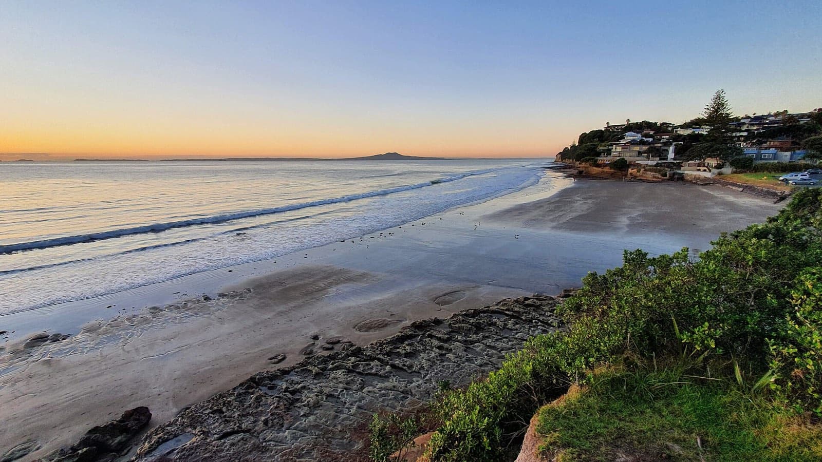 Low tide at Rothesay Bay, Auckland, with the rock platform and the cliffs, in May 2022
